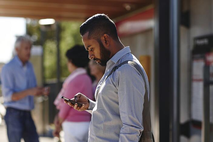 A man uses the transport real-time travel app on his phone