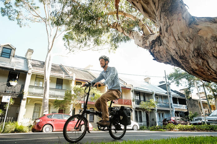 Man rides bike down bike route in Inner West Sydney